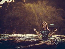 menina meditando em pedra do rio lajeado no rio grando do sul